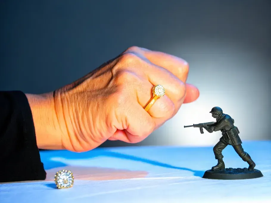 A symbolic representation of competitive market dynamics showing a person's fist facing a small armed soldier figurine