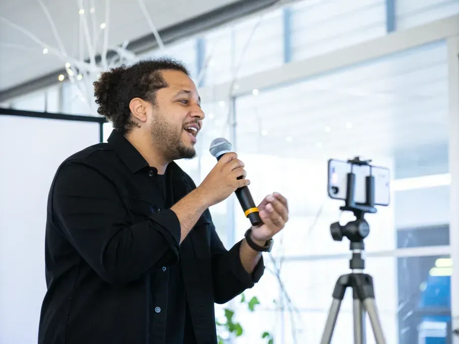 A startup founder passionately speaking into a smartphone in a modern office setting.