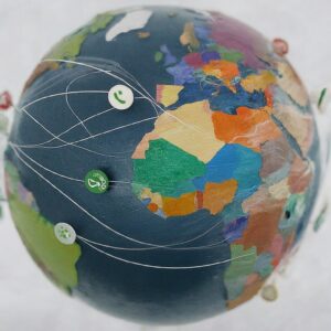 A colorful, patchwork globe with buttons and thread paths, symbolizing the interconnected and diverse nature of international services.