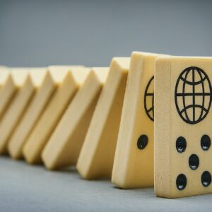 A row of dominoes with cultural symbols, poised to topple, metaphor for cultural sensitivity in marketing