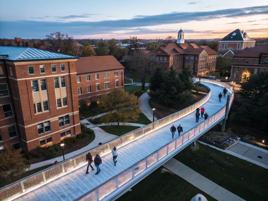 Aerial view of a university campus with students walking on a lit digital bridge connected to mental health services.