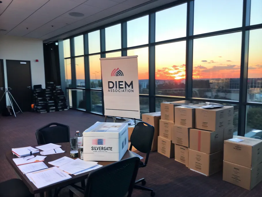 A modern office space being packed up, with boxes labeled 'Diem Association' and a sunset view.
