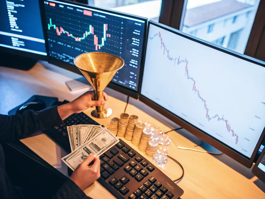 Cinematic overhead shot of a modern desk with glowing screens showing profit charts, a golden funnel, and flowing dollar bills.