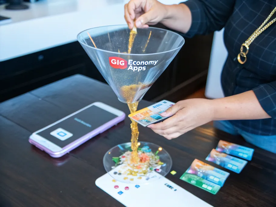 Hands holding a transparent glass funnel pouring streams of light into a banking card.